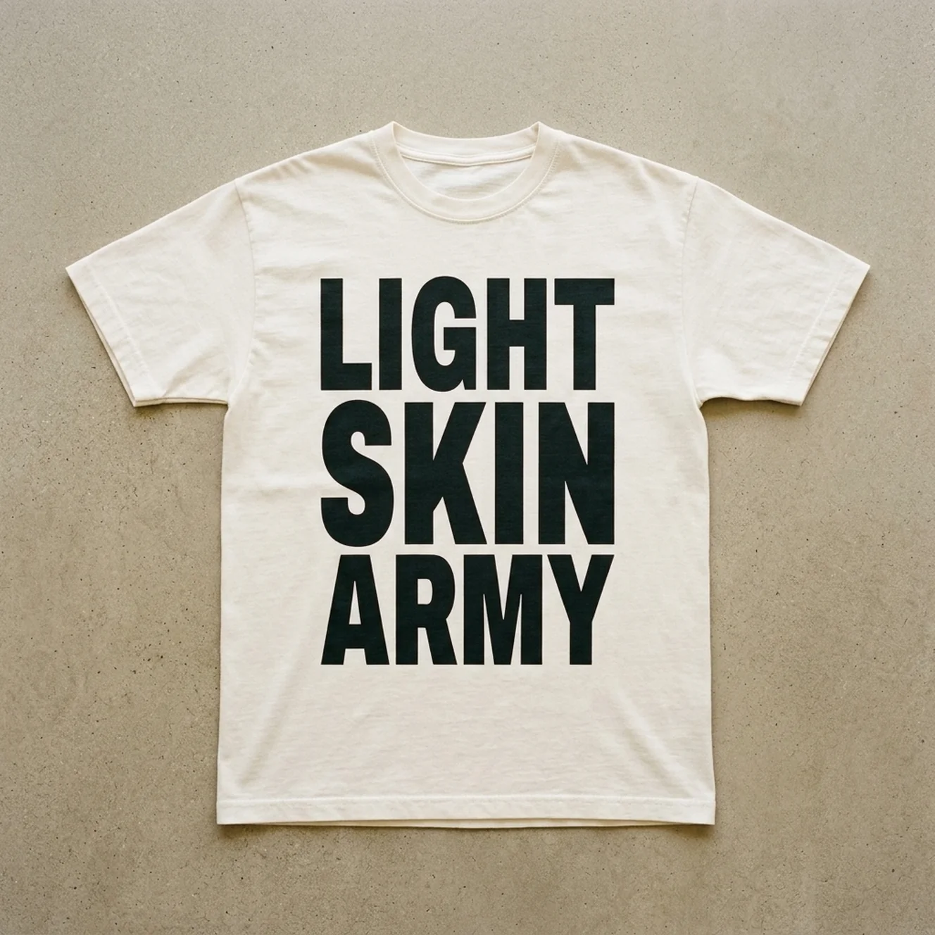 Loud & Proud tee in Ivory laid flat on warm concrete