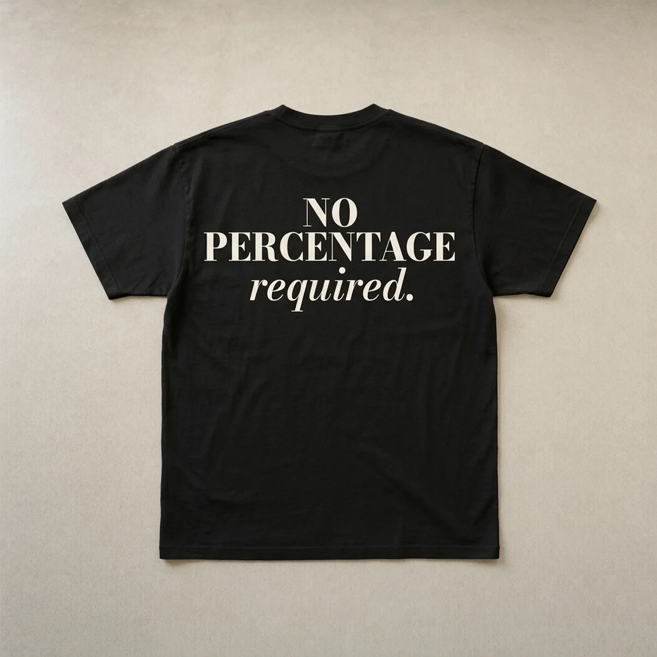 No Percentage tee in Black laid flat on warm concrete, back print showing