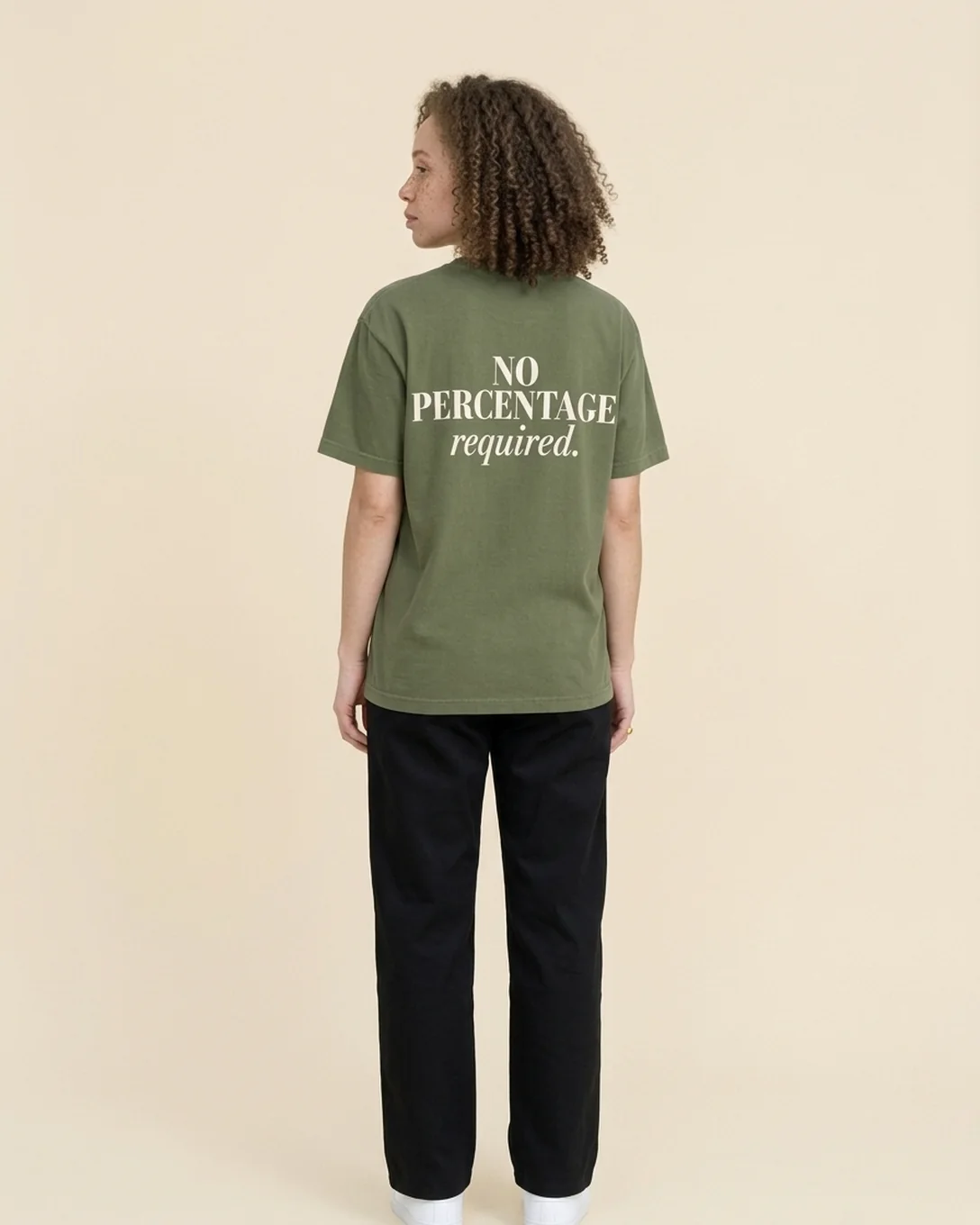 Back view of a model wearing the No Percentage tee in Moss, reading NO PERCENTAGE required.