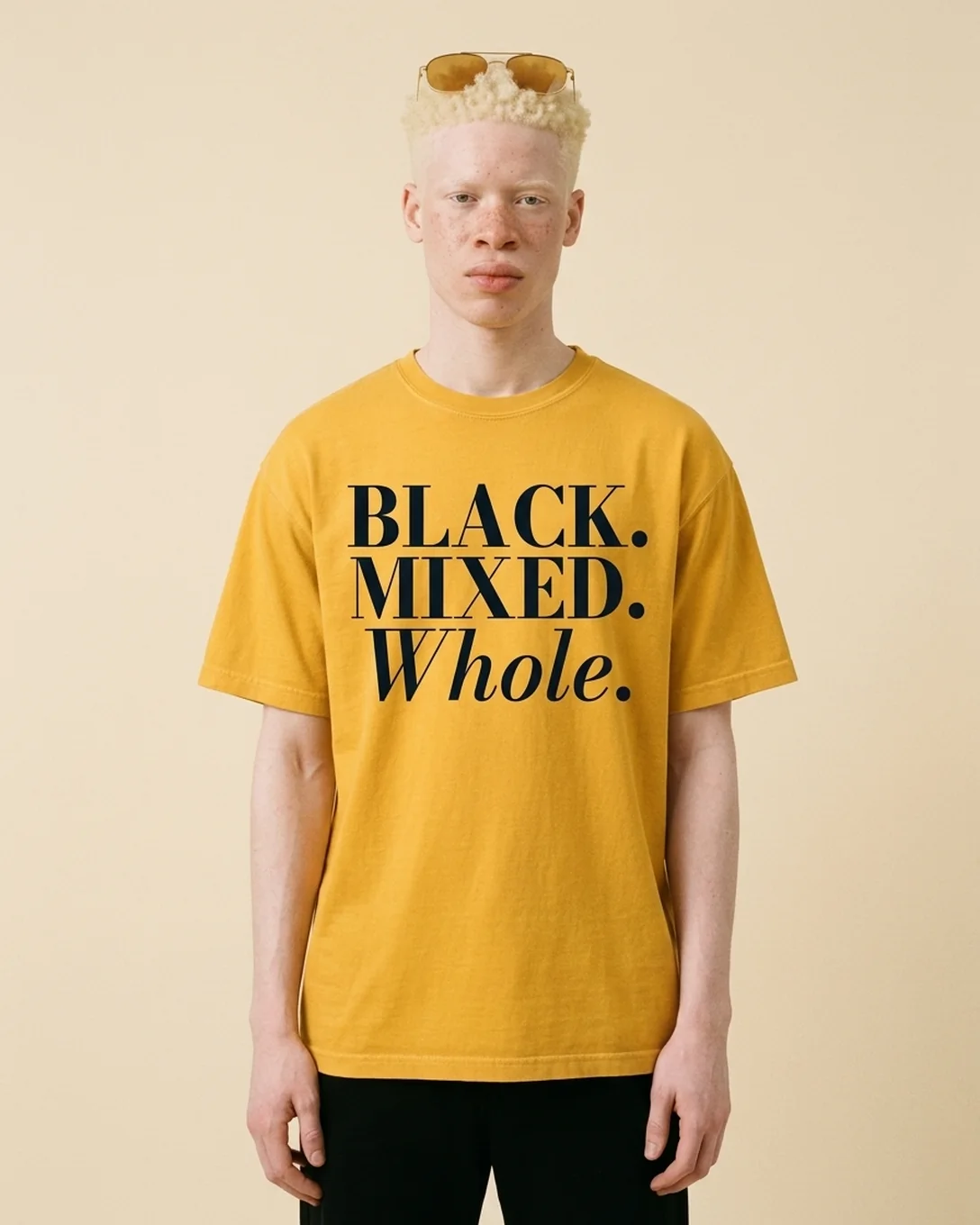Model wearing the Whole tee in Mustard, reading BLACK. MIXED. Whole.